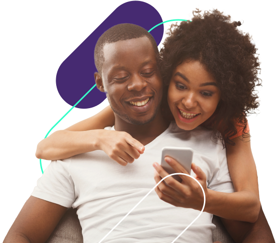 Um casal sorridente olhando para um smartphone juntos. Eles estão sentados próximos em um ambiente confortável, com a mulher apoiada no ombro do homem, ambos focados na tela do telefone.