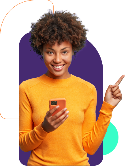 A descrição alternativa (alt text) para esta imagem poderia ser: "Mulher jovem e alegre usando uma blusa laranja, segurando um smartphone com a mão direita e apontando para cima com a esquerda. Ela tem cabelo encaracolado volumoso e um sorriso radiante, parecendo confiante e amigável.