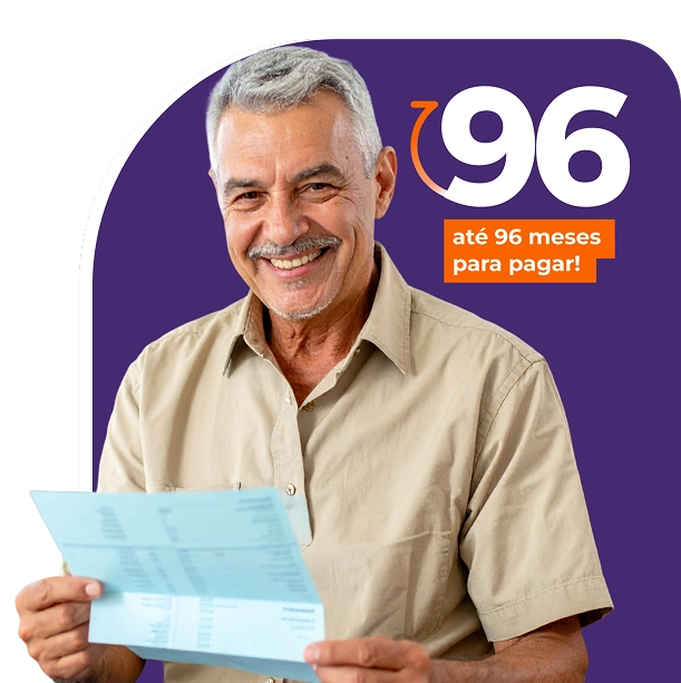 Um senhor segurando o celular com uma mão e interagindo com a tela com a outra mão. Seu olhar está direcionado ao celular e ele está sorrindo.